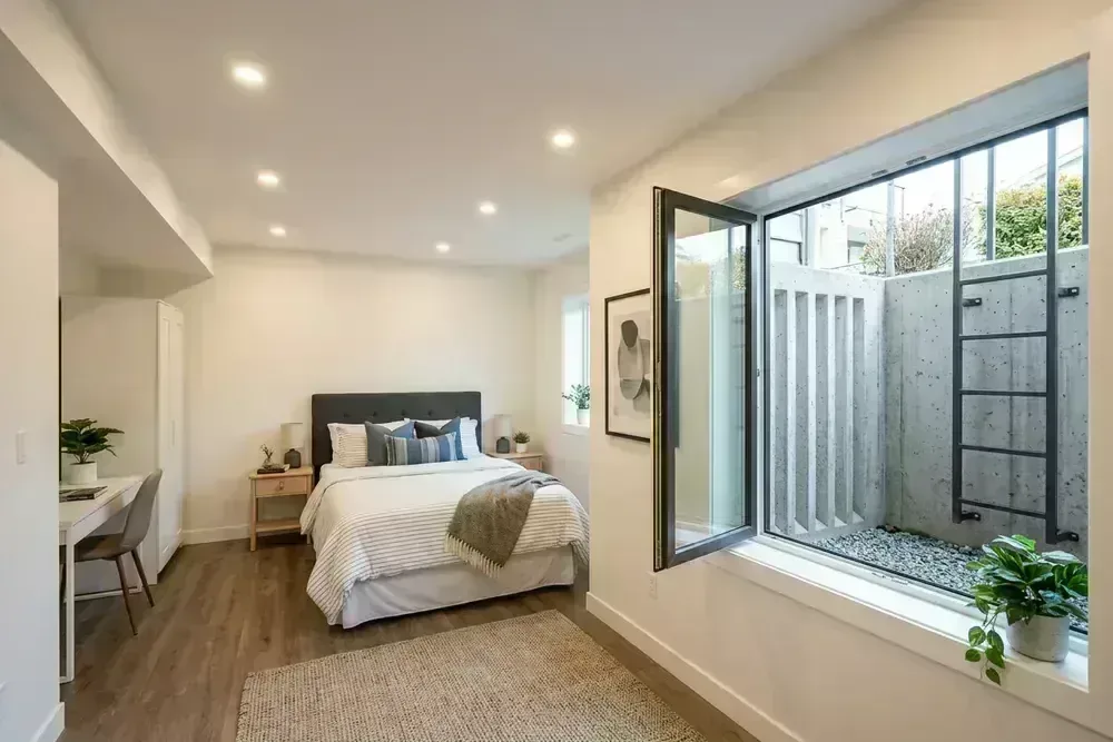 Finished basement bedroom with code-compliant egress window and 2.1 m ceiling
